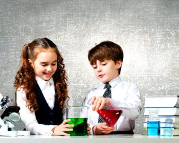 un garçon et une fille réalisent ensemble des experiences scientifiques dans le cadre d'un établissement scolaire