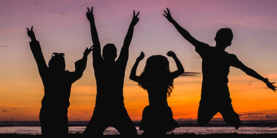 un groupe composé d'enfants et d'adolescents sautent de joie car les vacances débutent