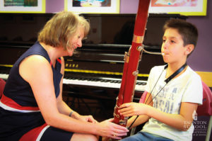 Un enfant joue d'un instrument de musique lors de son séjour en Angleterre organisé par Les Petits Atomes