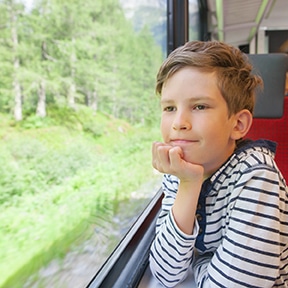 un enfant voyage en train pour se rendre en colonie de vacances activités nautiques et sciences.