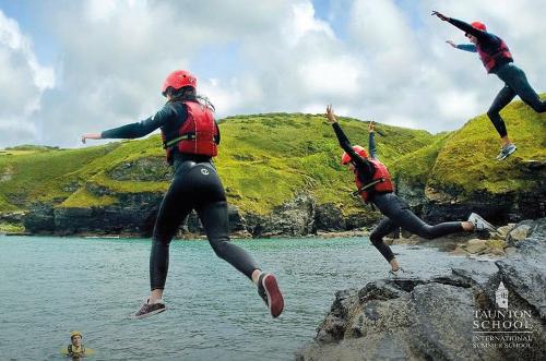 des enfants pratiquent le Coasteering lors de leur séjour linguistique en Angleterre et se baignent dans la mer