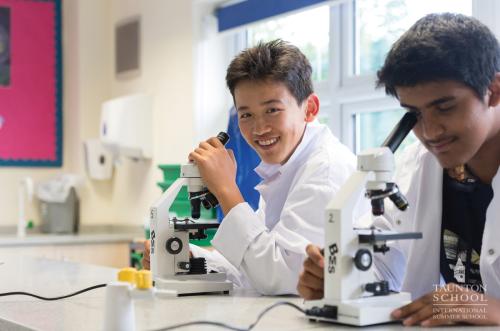 Un adolescent qui participe au séjour linguistique scientifique Les Petits Atomes en Angleterre apprend à observer au microscope